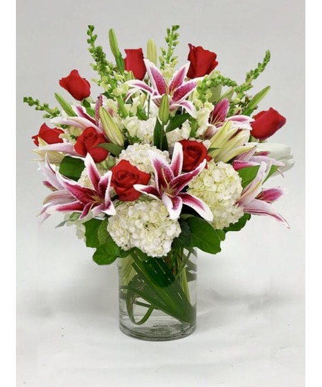 Bouquet of red roses, stargazer lilies, white snapdragons & white hydrangea in a glass vase. 